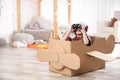 Cute little boy playing with binoculars and cardboard airplane Royalty Free Stock Photo