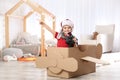 Cute little boy playing with binoculars and cardboard airplane Royalty Free Stock Photo