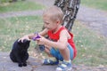 Cute little boy playing with a cat outdoors Royalty Free Stock Photo