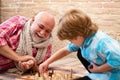Cute little boy playing chess. Childhood. Cute little boy playing chess. Generations. Handsome grandpa and grandson are