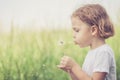 Cute little boy playing with flowers in park