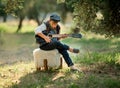 Cute little boy is playing guitar in the park Royalty Free Stock Photo