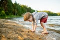 Cute little boy playing by a lake or river on hot summer day. Adorable child having fun outdoors during summer vacations Royalty Free Stock Photo