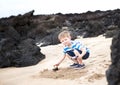 Cute little boy playing with lava rocks Royalty Free Stock Photo