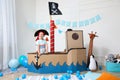 Cute little boy playing with pirate cardboard ship and toys at home. Child`s room interior Royalty Free Stock Photo