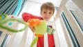 Cute little boy playing toys with his little baby brother lying in crib. Concept of family happiness and baby Royalty Free Stock Photo