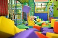 Cute little boy plays with soft cubes in the dry pool in play center. Kid playing on indoor playground in foam rubber pit in Royalty Free Stock Photo