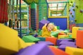 Cute little boy plays with soft cubes in the dry pool in play center. Kid playing on indoor playground in foam rubber pit in Royalty Free Stock Photo