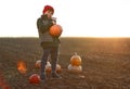 Cute little boy with pumpkins in autumn field Royalty Free Stock Photo