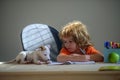 Cute little boy with puppy dog doing her homework. Education childhood and school concept - cute little student with pet Royalty Free Stock Photo