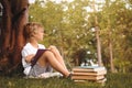 Cute little boy reading book on green grass near tree Royalty Free Stock Photo