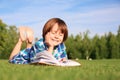 Cute little boy reading book in park on sunny day Royalty Free Stock Photo