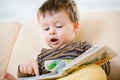 Cute little boy reading book on sofa Royalty Free Stock Photo