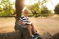 Cute little boy reading book on tree in park Royalty Free Stock Photo