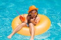 Cute little boy relaxing with toy ring floating in a swimming pool having fun on summer vacation. Happy child playing in Royalty Free Stock Photo