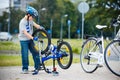 Cute little boy repairing his bicycle outdoors Royalty Free Stock Photo