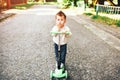 Pretty little boy riding scooter outdoor on the street Royalty Free Stock Photo