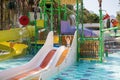 Cute little boy rolls down a water slide in a aquapark. Activities in the pool. Concept summer vacation, rest, fun Royalty Free Stock Photo