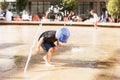 Little boy running under water jet in fountain Royalty Free Stock Photo