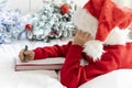 cute little boy in Santa Claus hat writes letter to Santa Claus to get gift lying on bed against background of Christmas Royalty Free Stock Photo