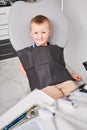 Cute little boy sitting in dental chair in stomatological cabinet. Royalty Free Stock Photo