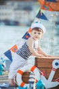 Cute little boy sitting on the floor on pier outdoor, a marine style. Little sailor Royalty Free Stock Photo