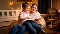 Cute little boy sitting with mother at night and reading bedtime story book. Concept of child education and family Royalty Free Stock Photo