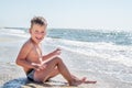 Cute little boy sitting at ocean beach Royalty Free Stock Photo