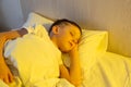 Cute little caucasian boy sleeping in his comfortable bed in the morning under yellow sun light. Good morning Royalty Free Stock Photo