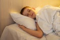 Cute little caucasian boy sleeping in his comfortable bed in the morning under yellow sun light. Good morning Royalty Free Stock Photo