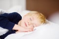 Cute little boy sleeping. Tired child taking a nap in parent`s bed. Royalty Free Stock Photo