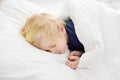 Cute little boy sleeping. Tired child taking a nap in parent`s bed. Royalty Free Stock Photo