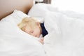 Cute little boy sleeping. Tired child taking a nap in parent`s bed. Royalty Free Stock Photo