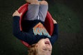 Cute little boy spinning on playground equipment with huge big smile and shirt with word RAD