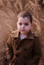 Cute little boy standing in a field.