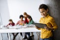 Cute little boy standing in front of kids programming electric toys and robots at robotics classroom