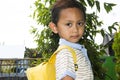 Cute little boy standing looking sideways wearing yellow school bag Royalty Free Stock Photo