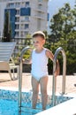 Cute little boy standing on swimming pool steps Royalty Free Stock Photo
