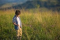A cute little boy stands in field and looks down Royalty Free Stock Photo