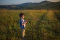 Cute little boy stands on a field at the sunset Royalty Free Stock Photo