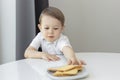 Cute little boy stealing delicious cookies on table, child try to take cookies from plate, kids sugar addiction concept