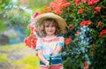 Cute little boy in straw hat is laughing with water spraying hose. Royalty Free Stock Photo