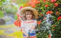 Cute little boy in straw hat is laughing with water spraying hose. Royalty Free Stock Photo