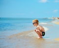 Cute little boy in sunglasses sitting at beach Royalty Free Stock Photo