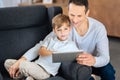 Cute little boy surfing the web together with his father