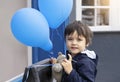 Cute little boy with teddy bear holding blue balloon with smiling face, Happy child playing with air balloons outdoor, Kid having Royalty Free Stock Photo