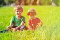 Cute little boy and toddler girl playing on green grass Royalty Free Stock Photo