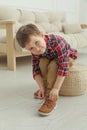 Cute little boy tying shoe laces at home Royalty Free Stock Photo