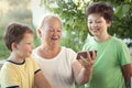Cute little boy using smartphone with grandma at home veranda Royalty Free Stock Photo