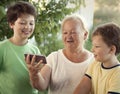 Cute little boy using smartphone with grandma at home veranda Royalty Free Stock Photo